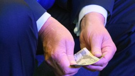 Donald Trump numără atent câteva bancnote de 20 de dolari înainte de a face o donație la biserică
